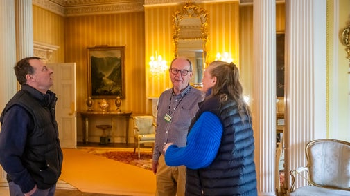 Volunteer room guide speaking to visitors at Hinton Ampner